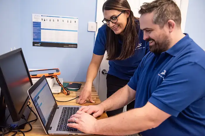 Evolution-Physio employees working on a laptop